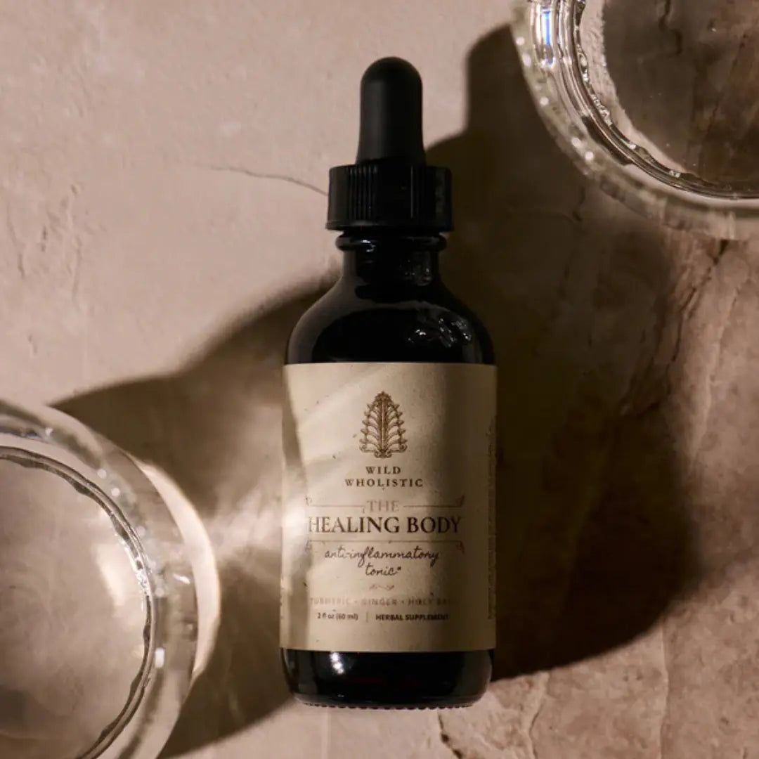Bottle of 'Healing Body' supplement with dropper on a textured surface