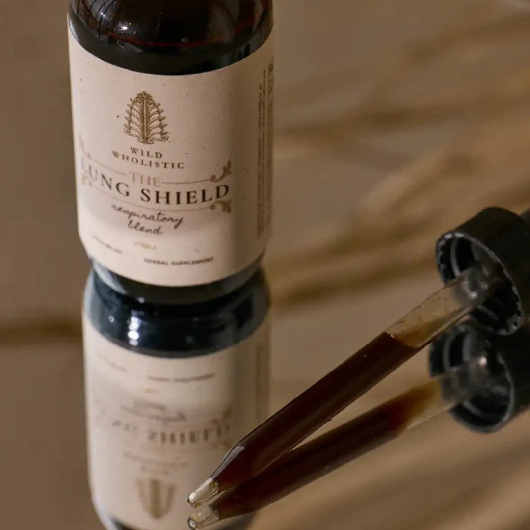 Bottle of 'The Lung Shield' supplement with dropper on a reflective surface