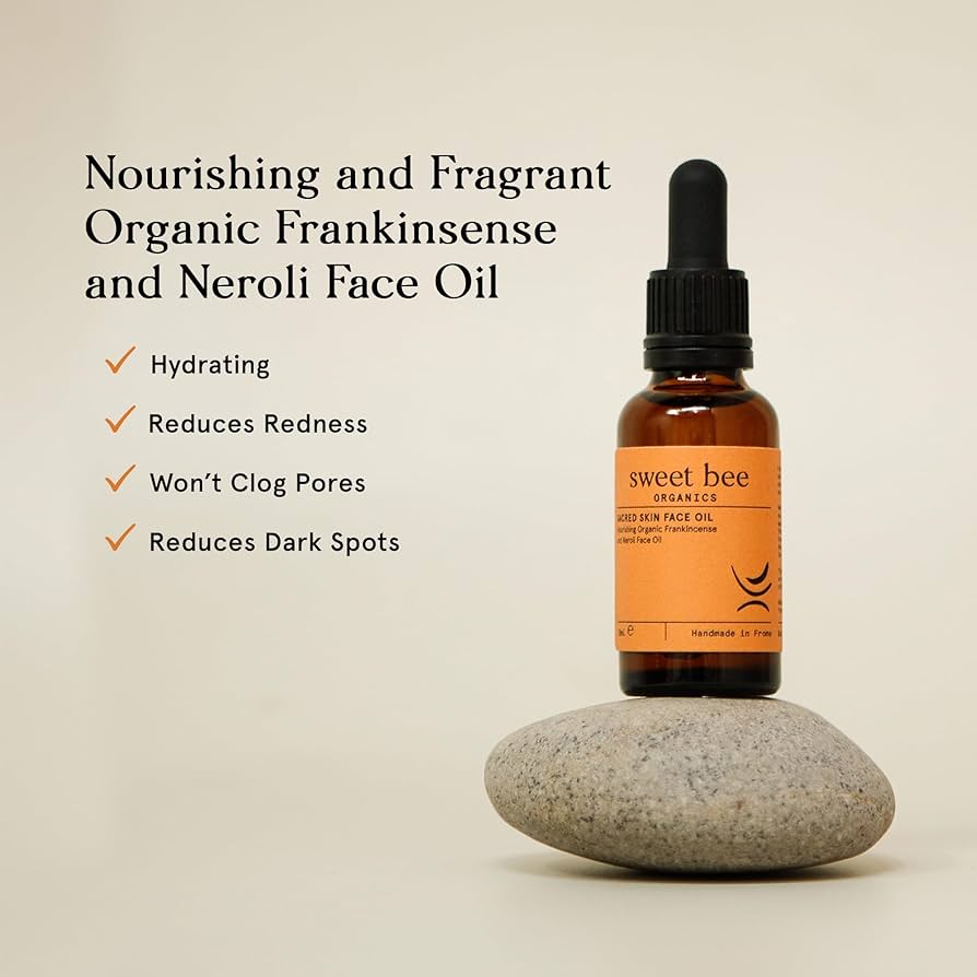 Bottle of sweet bee Organics Frankincense and Neroli Face Oil on a stone with product benefits listed.