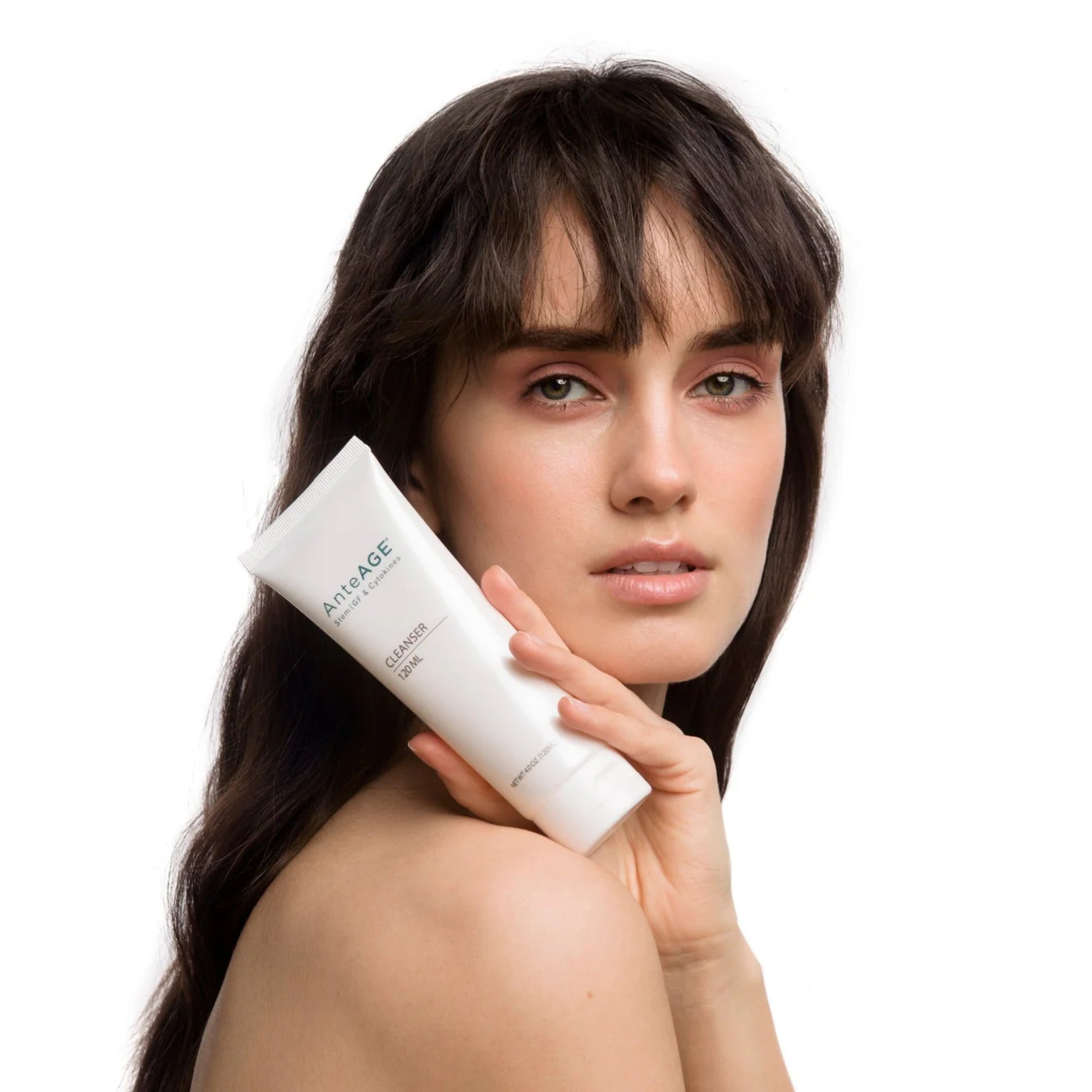 Woman holding an anteage skincare product with a white background