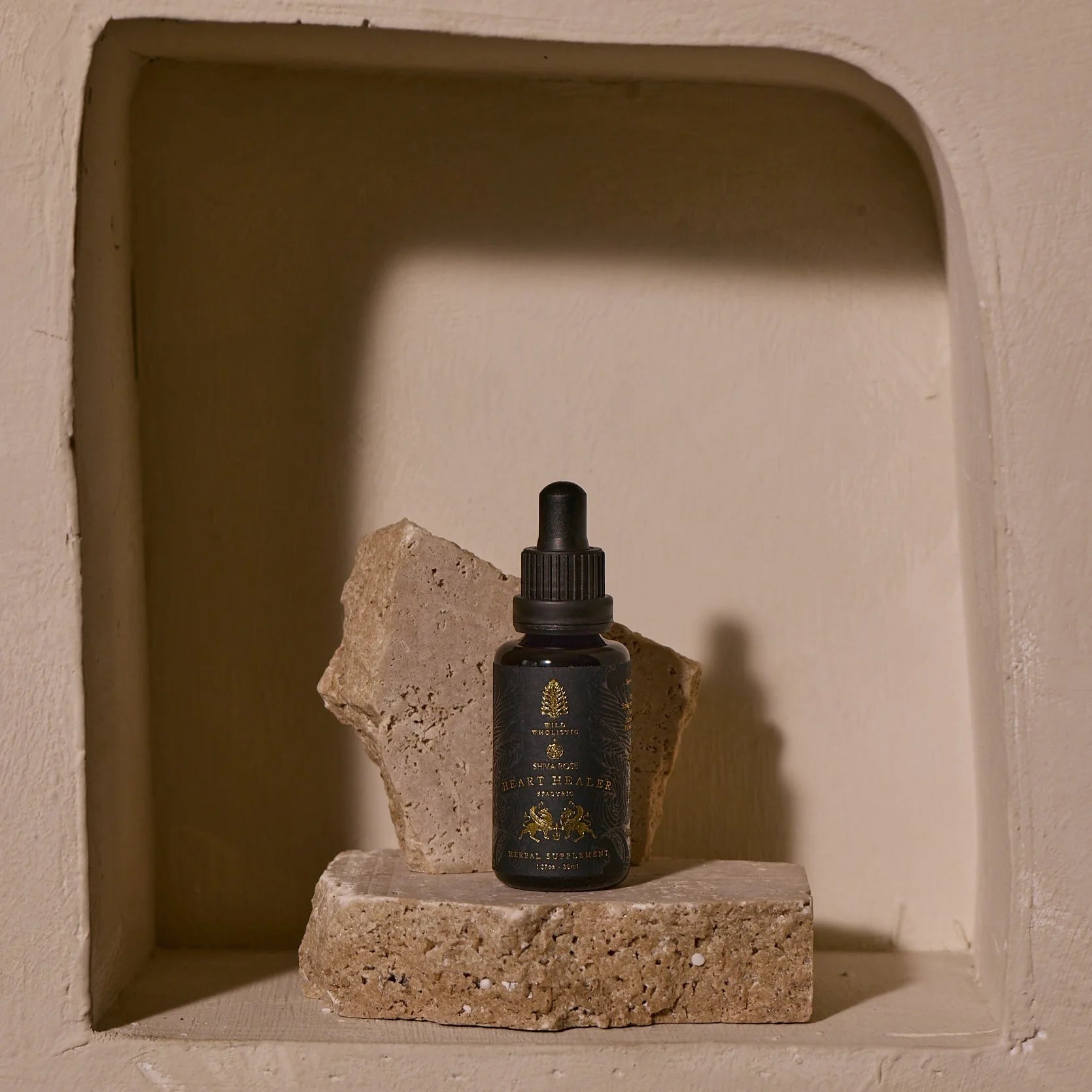 Bottle of Heart Healer with dropper on a stone block against a textured wall