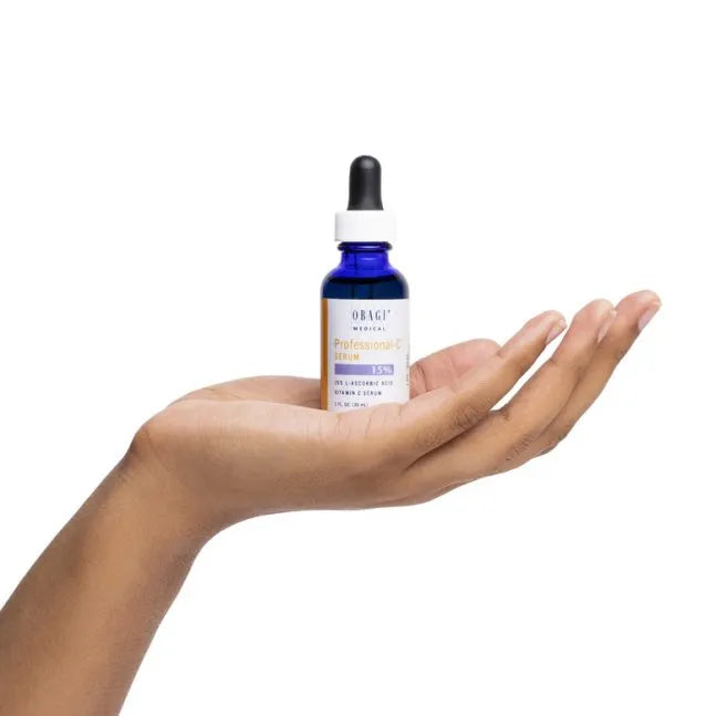 Hand holding a blue dropper bottle labeled 'Dr. Jart' on a white background