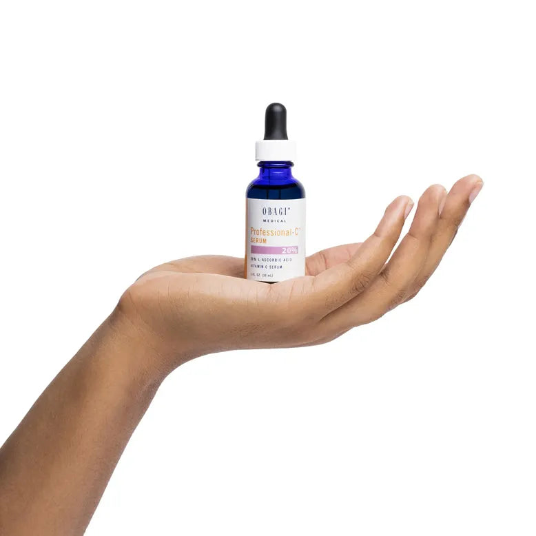 Hand holding a blue Obagi dropper bottle with a white label against a white background