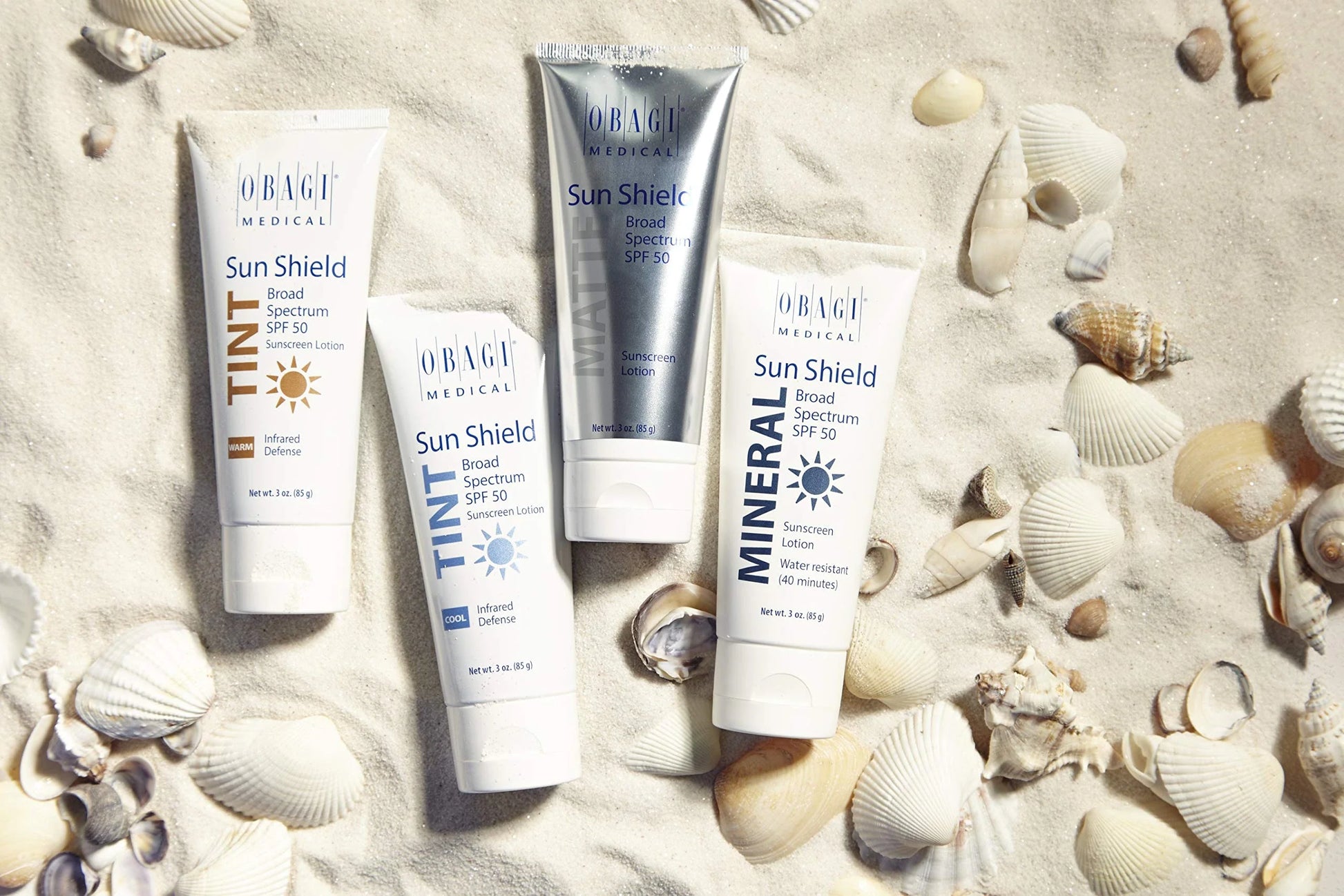 Obagi Sun Shield products on sand with shells
