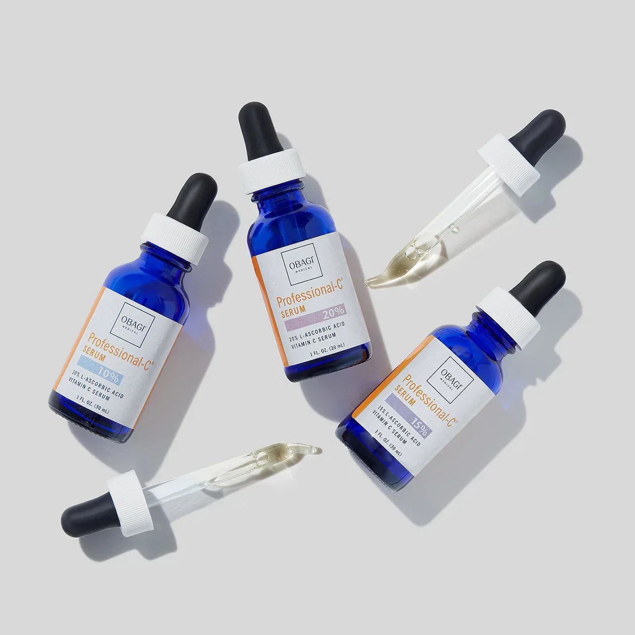 Obagi Professional-G Serum bottle on a surface with a plant and other skincare products in the background.