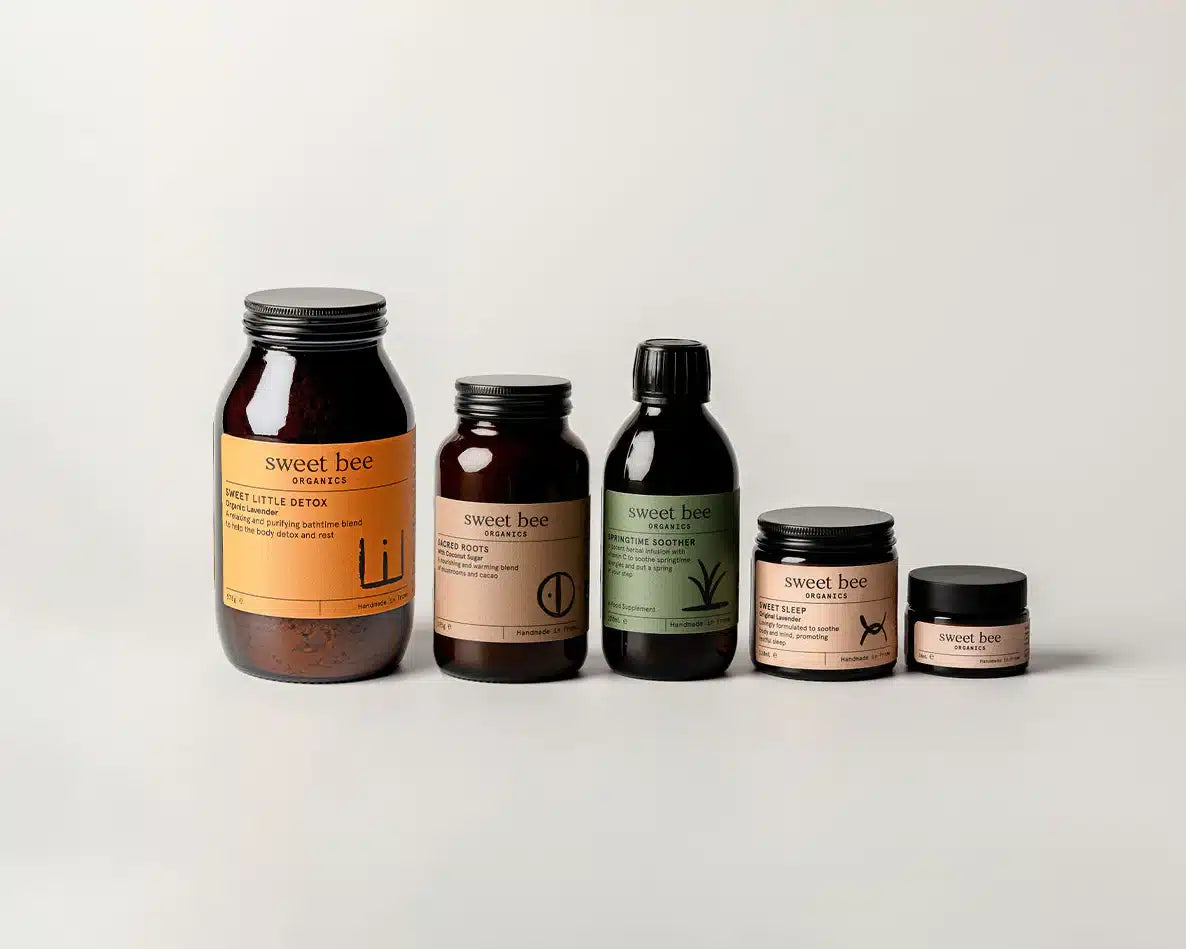 Collection of 'sweet bee' skincare products on a light gray background