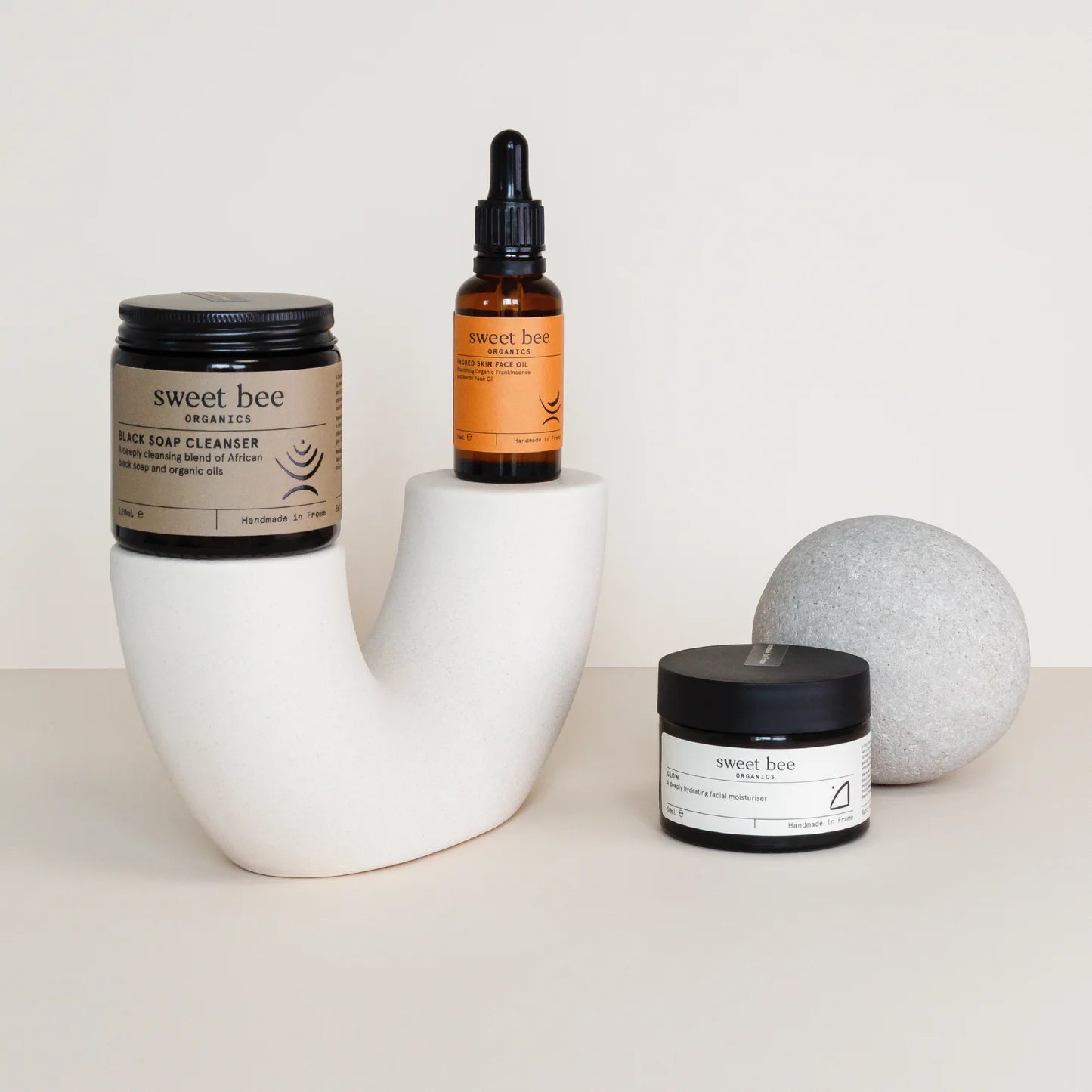 Sweet Bee Organics skincare products on a white surface with a neutral background