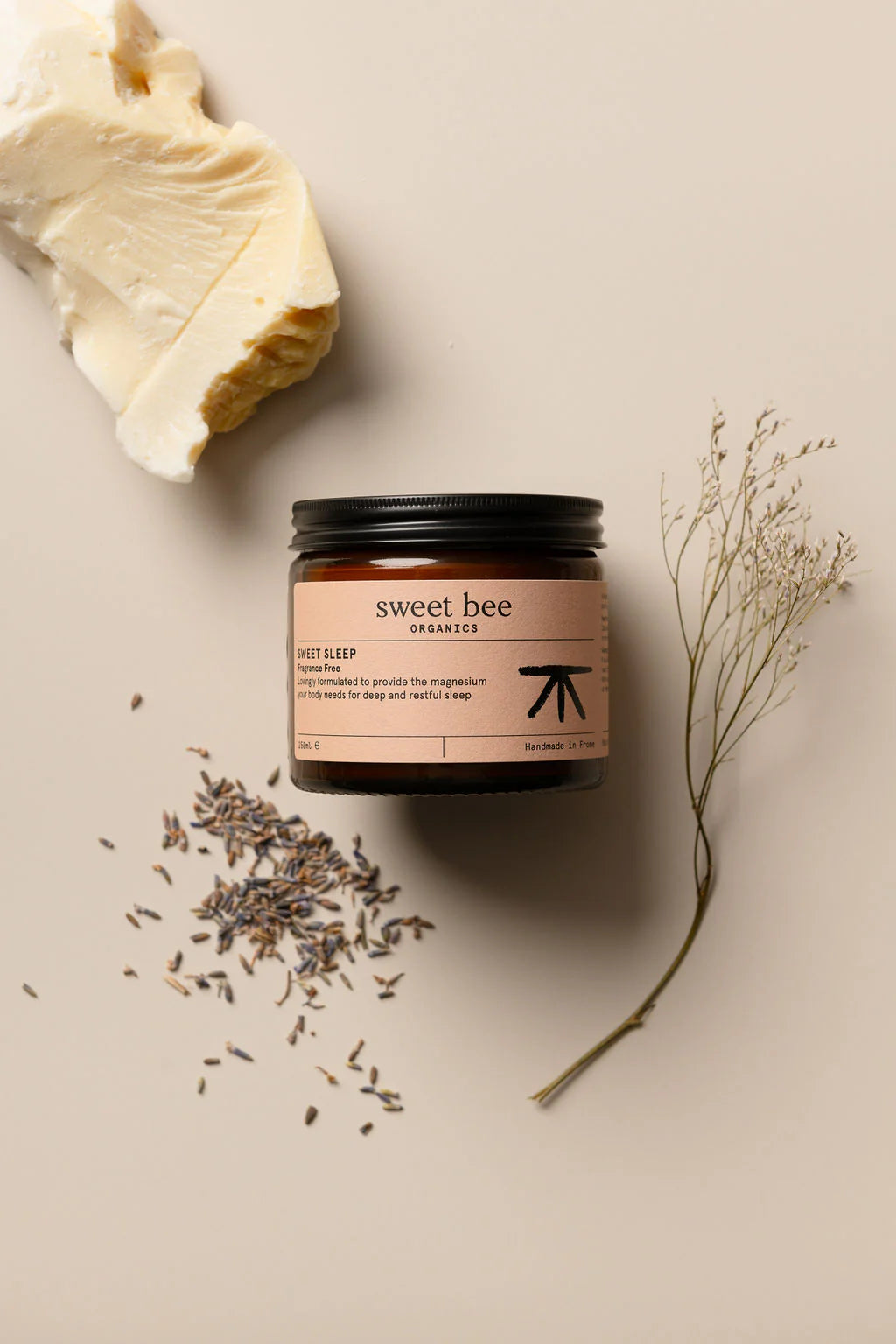 Jar of 'sweet bee' product with lavender and a leaf on a beige background