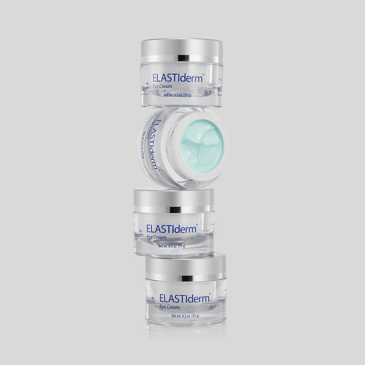 Stack of ELASTIderm eye cream jars on a light gray background