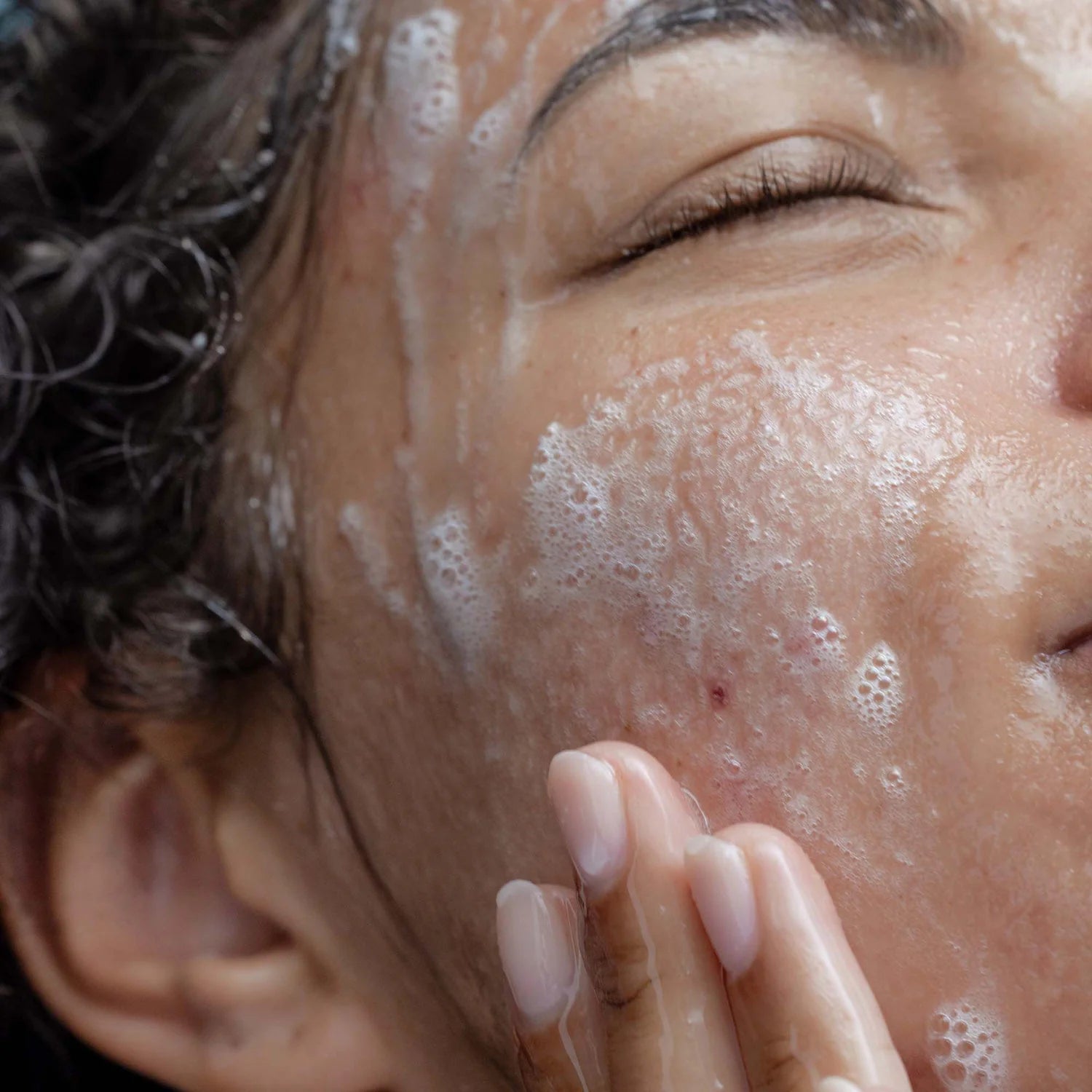 Person applying a skincare product with foam on their face