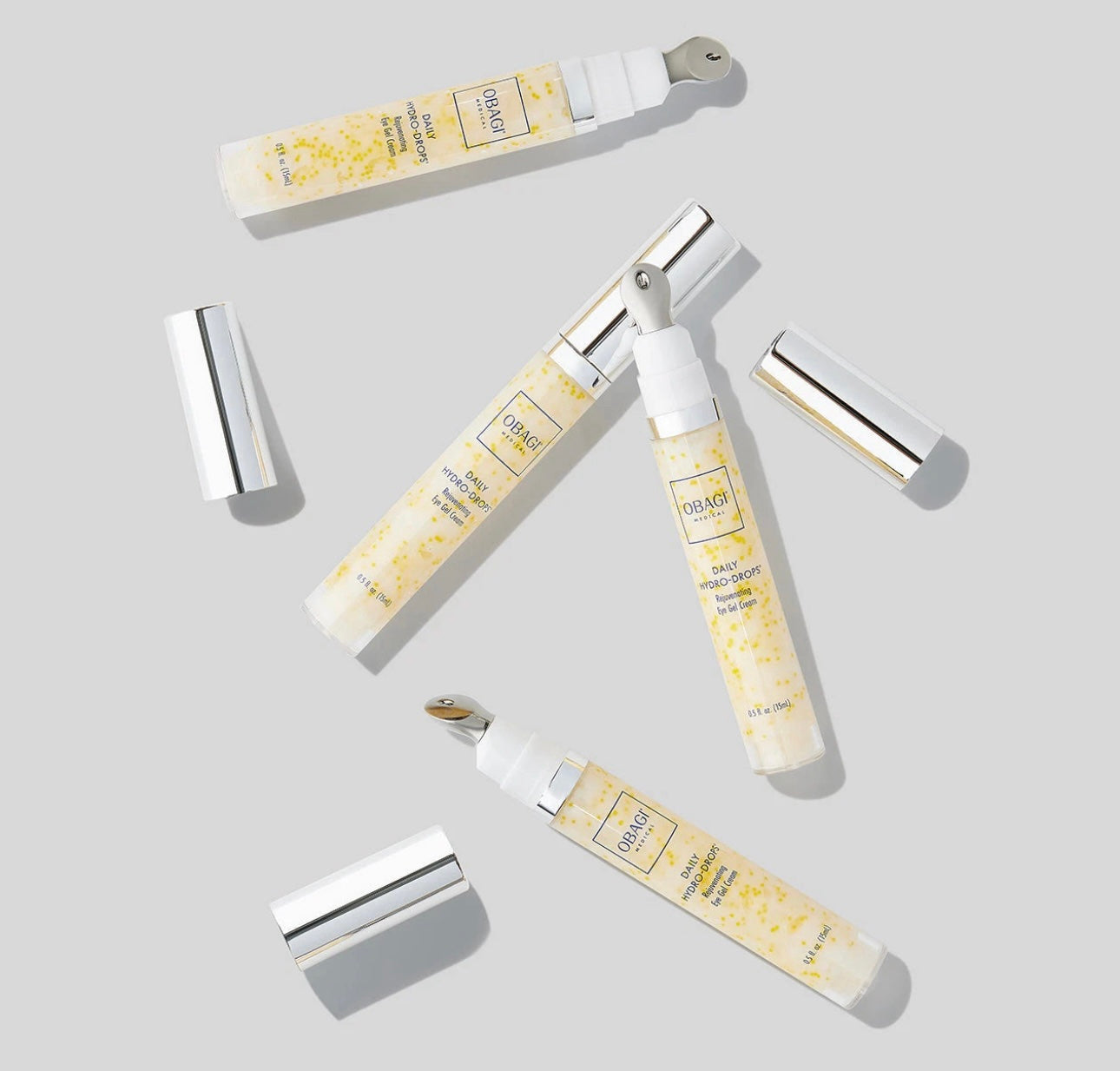 Set of skincare products with applicators on a light gray background
