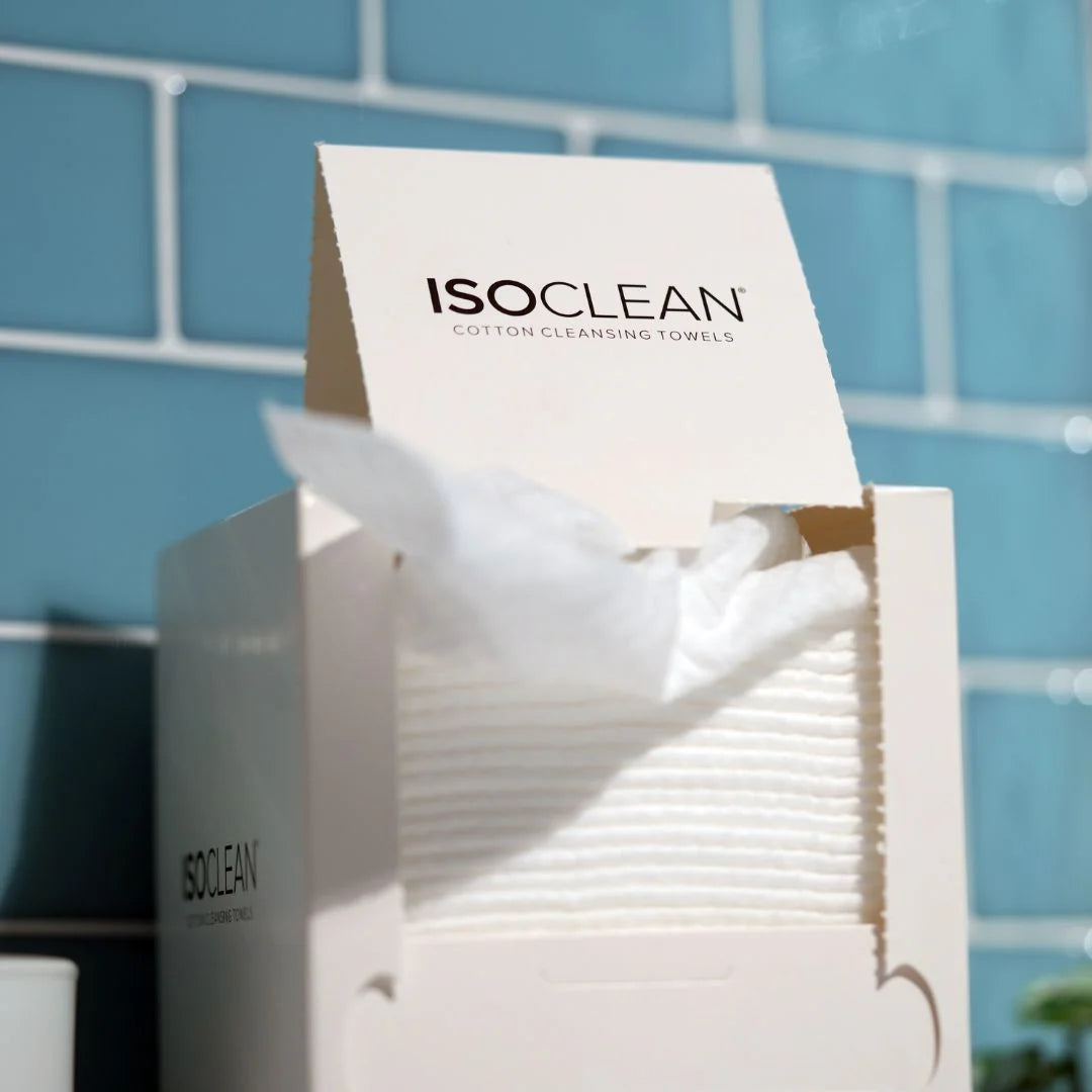 ISO CLEAN cotton cleansing towels packaging with towels peeking out against a blue tiled wall.