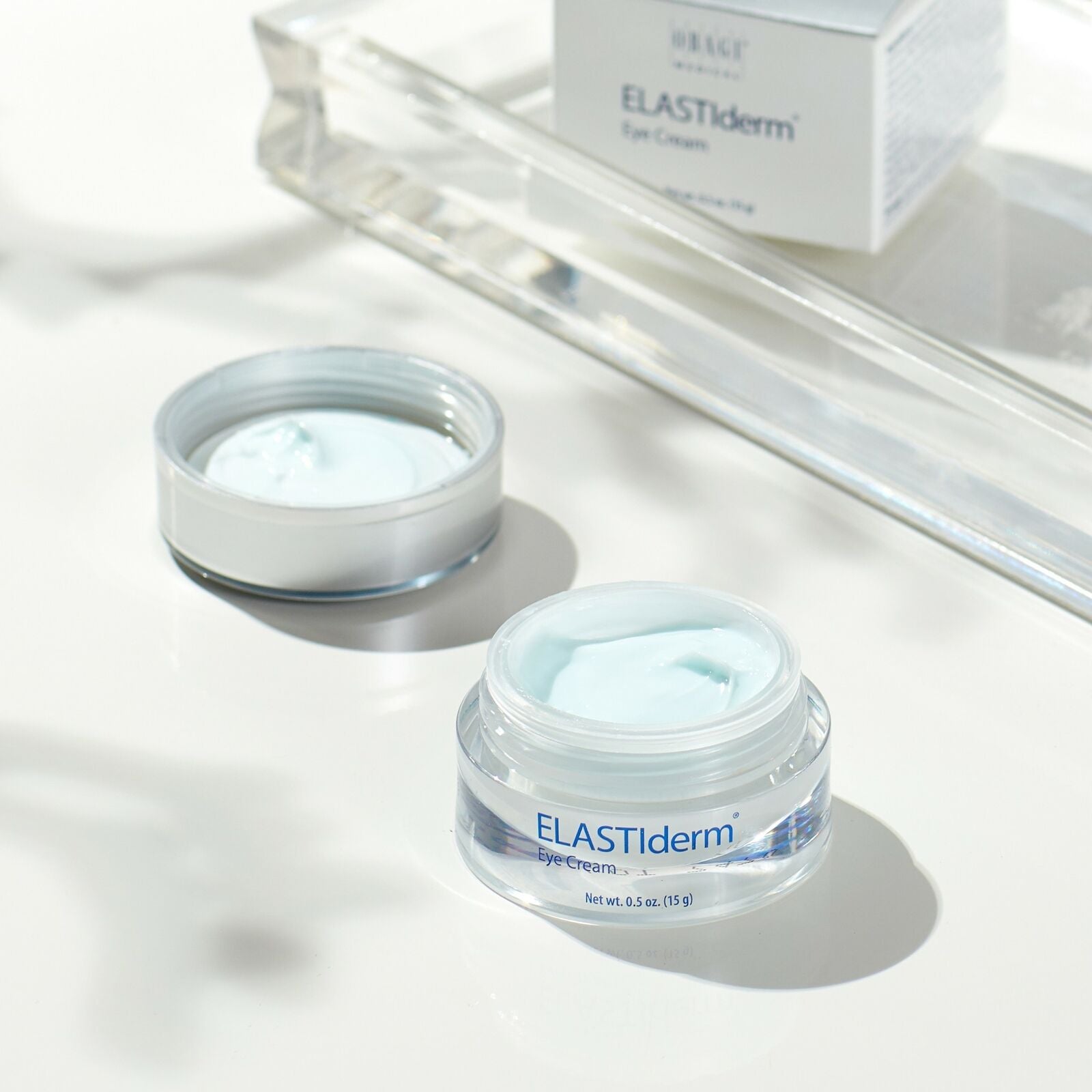 ELASTIderm eye cream jars on a white surface with a mirror in the background