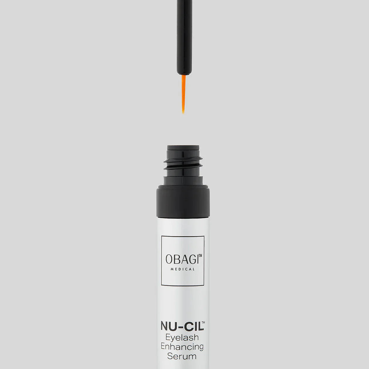 Obagi NU-CIL eyelash enhancing serum bottle with dropper on a light gray background