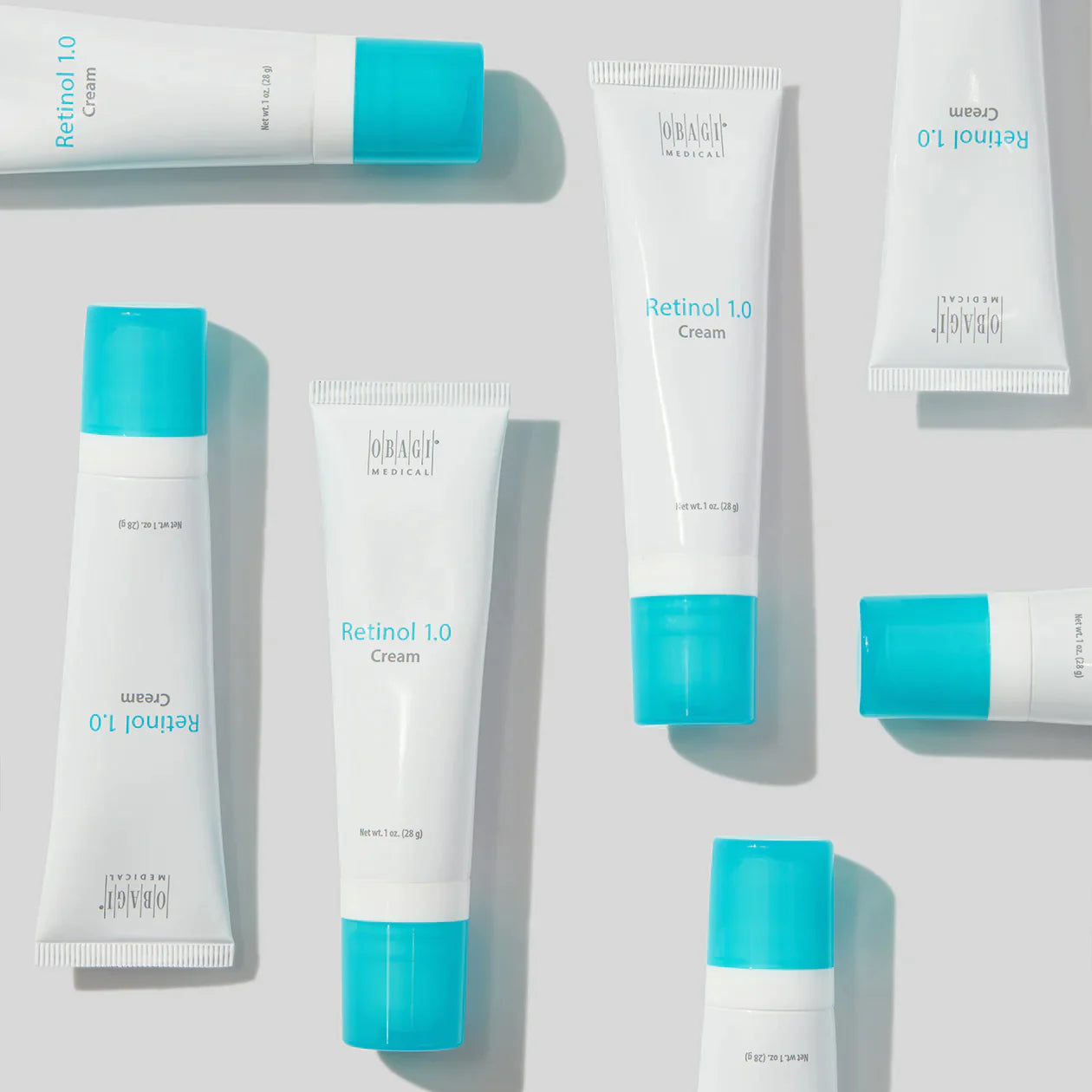 Multiple tubes of Retinol 1.0 Cream with blue caps on a light gray background
